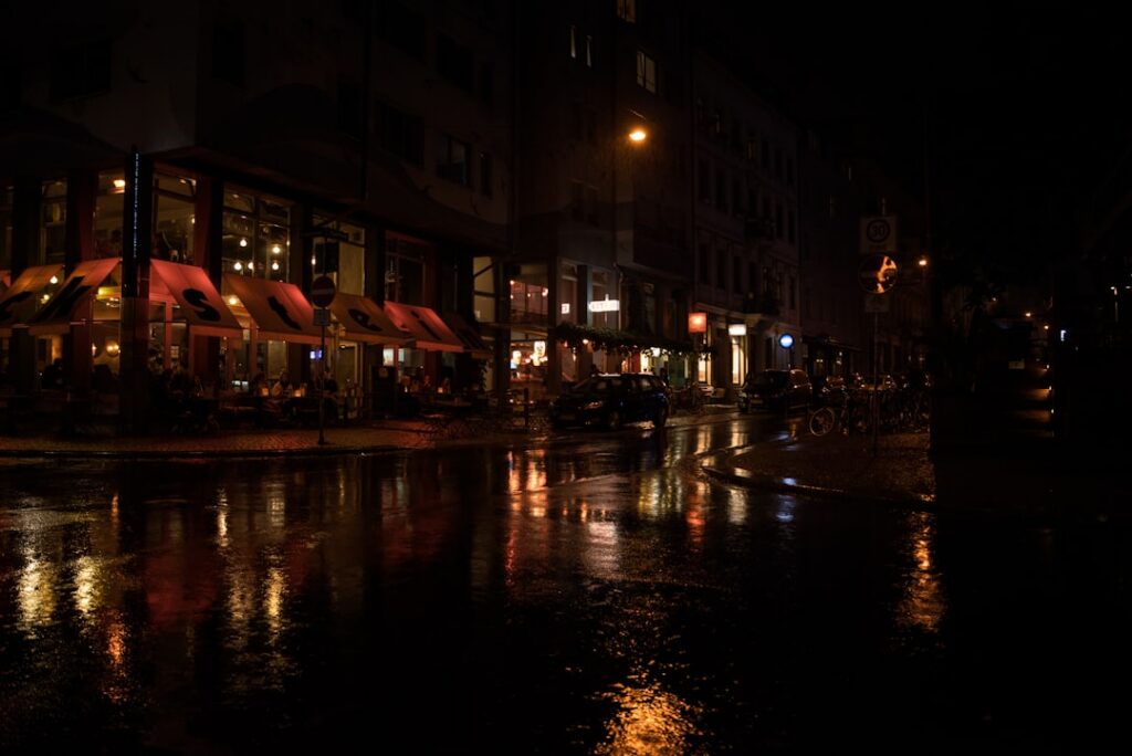 雨夜城市街道与行人倒影，呼应在雨天重新观察城市细节。摄影：Leon S / Unsplash
